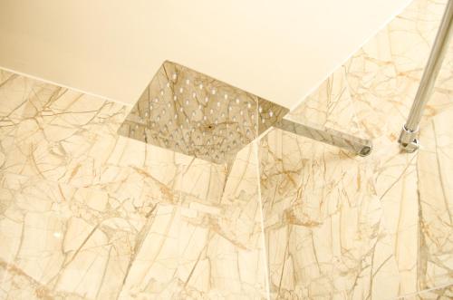 a white marble wall with a shower head at Terlon Apartments in Liverpool