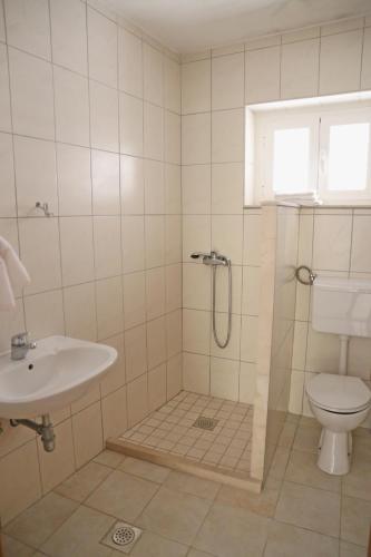 a bathroom with a shower and a toilet and a sink at Beach Villa Olivia in Lumbarda