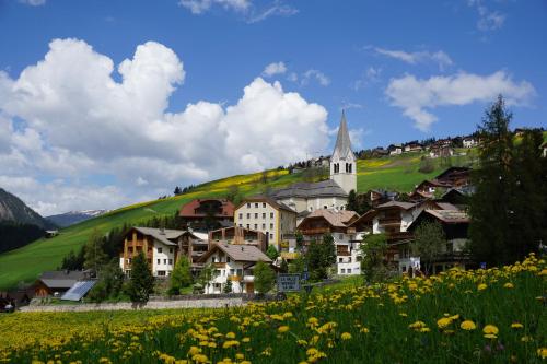 a village with a church and a field of flowers at La Palsa in La Valle