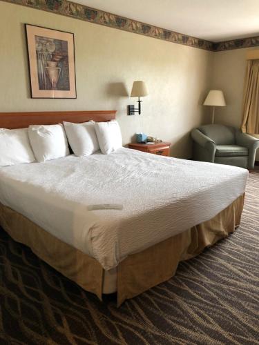 a hotel room with a large bed and a chair at The Ashley Inn of Tillamook in Tillamook