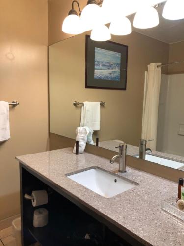 a bathroom with a sink and a large mirror at The Ashley Inn of Tillamook in Tillamook