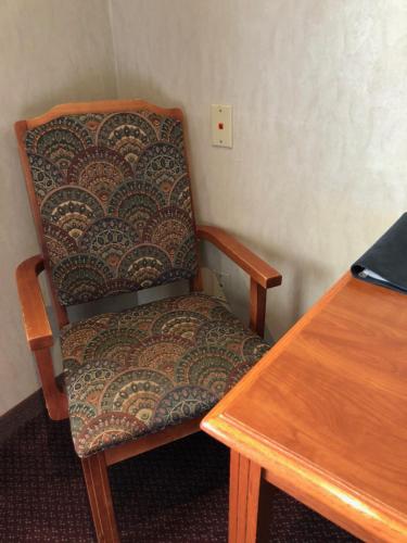 a chair in a room with a wooden table at The Ashley Inn of Tillamook in Tillamook