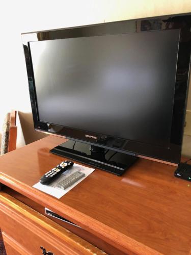 a television on a wooden table with a remote control at The Ashley Inn of Tillamook in Tillamook
