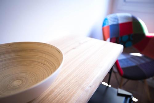 a wooden bowl sitting on a table next to a chair at B&B Da Peppa in Castellammare del Golfo