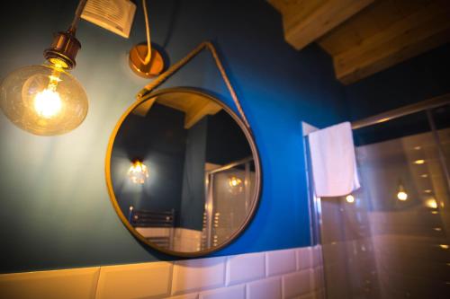 a mirror hanging on a blue wall with lights at B&B Da Peppa in Castellammare del Golfo