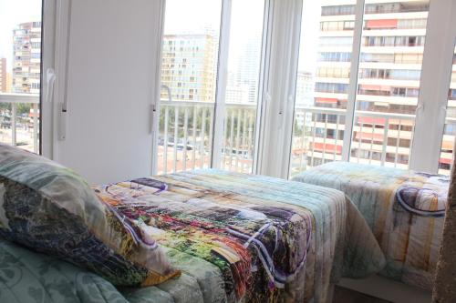 a bedroom with a bed and a large window at La Mamma Mía in Benidorm