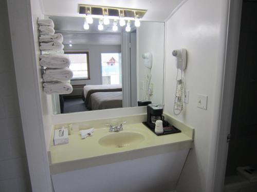 a bathroom with a sink and a mirror at Cassville Budget Inn in Cassville