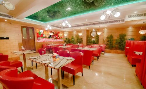 a restaurant with red chairs and tables in a room at Divinity by Audra Hotels in Mathura