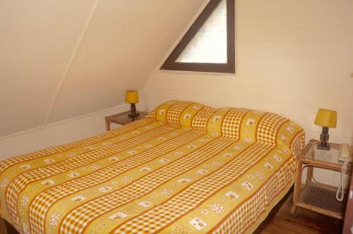 a bedroom with a bed with a yellow comforter and a window at Cabañas 4 Esquinas in La Serena