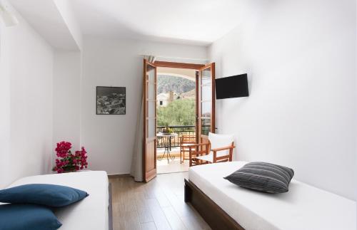 two beds in a room with a balcony at Venetia Apartments in Monemvasia