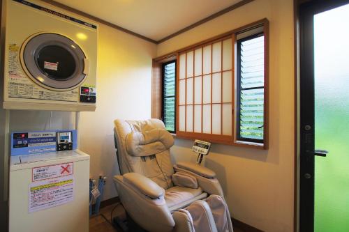 a hospital room with a reclining chair and a microwave at Hatago Tsubakiya in Yamanakako