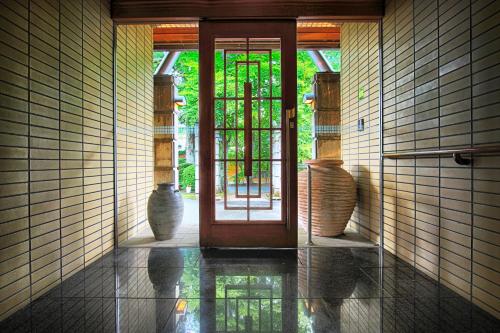an open door in a room with vases on the floor at Hatago Tsubakiya in Yamanakako