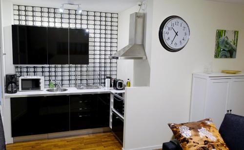 eine Küche mit einer Theke und einer Uhr an der Wand in der Unterkunft KR studio apartment Harju in Helsinki