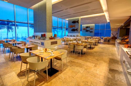 a restaurant with tables and chairs and large windows at Estelar Cartagena de Indias Hotel y Centro de Convenciones in Cartagena de Indias