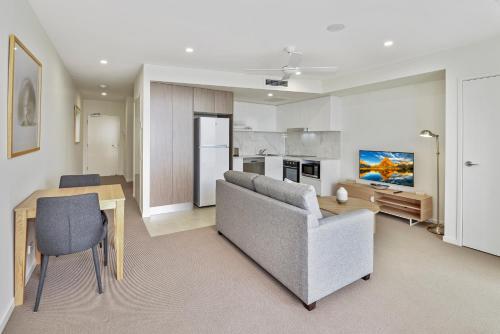 a living room with a couch and a table at Aquarius Kawana in Kawana Waters