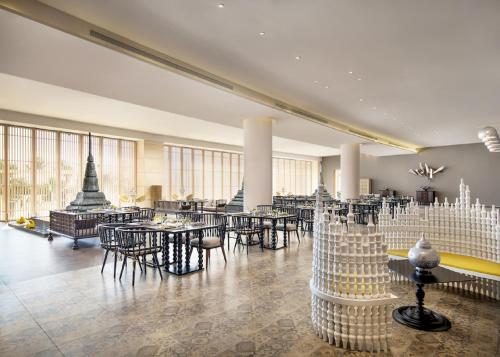 a restaurant with tables and chairs in a room at The Mangrovetree Sanya Resort in Sanya