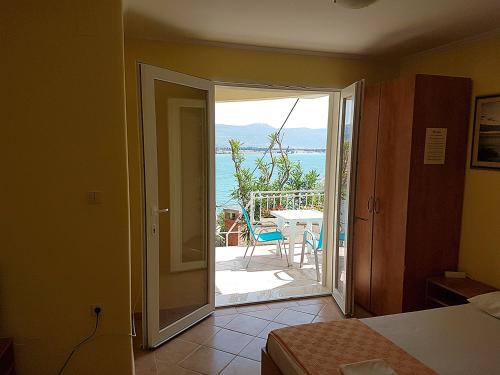 um quarto com uma porta que abre para um pátio com vista em Antonio Apartments em Trogir