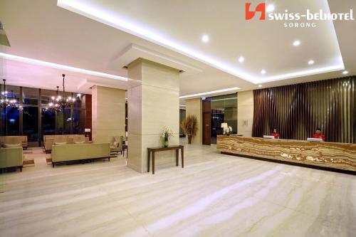 a living room filled with furniture and a large mirror at Swiss-Belhotel Sorong in Sorong