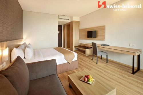 a hotel room with a bed and a desk at Swiss-Belhotel Sorong in Sorong