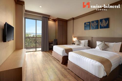 a hotel room with two beds and a television at Swiss-Belhotel Sorong in Sorong
