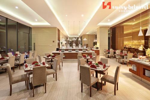 a dining room with tables and chairs in a restaurant at Swiss-Belhotel Sorong in Sorong