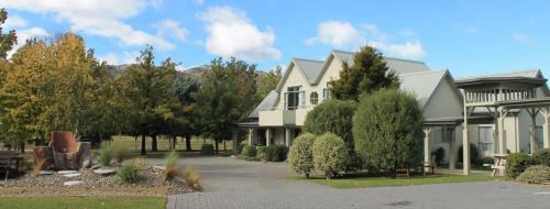 a large white house with trees and a courtyard at Colonial Manor Motel in Cromwell