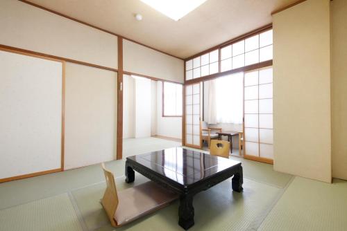 a room with a table and chairs and windows at Matsukaneya Annex in Zao Onsen