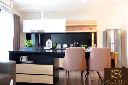 a kitchen with a table and chairs in a room at Wellness Chiang Mai Hotel in Chiang Mai