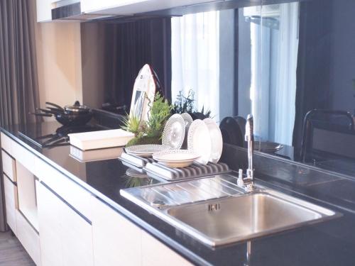 a kitchen sink with plates and dishes on a counter at Wellness Chiang Mai Hotel in Chiang Mai