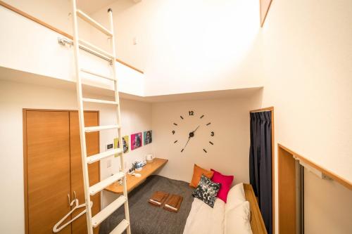 Habitación con cama elevada y reloj en la pared en Maison de Takinogawa, en Tokio