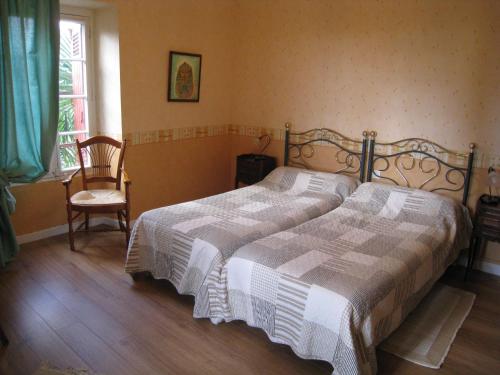 - une chambre avec un lit et une chaise dans l'établissement Chambres d'Hôtes Closerie du Guilhat, à Salies-de-Béarn