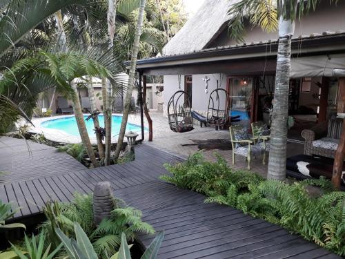 Casa con terraza de madera junto a la piscina en Lodge Afrique, en St Lucia