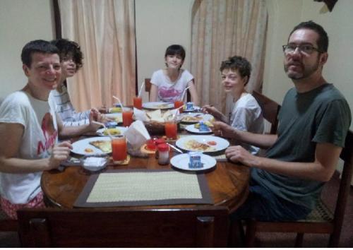 a group of people sitting around a table eating food at Mama's Hostel by Taprobane in Negombo