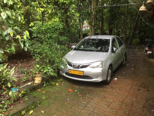 a small silver car parked in a driveway at Periyar Heritage in Thekkady