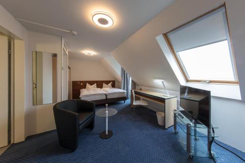 ein Hotelzimmer mit einem Bett, einem Schreibtisch und einem Stuhl in der Unterkunft Royal Hotel Zurich in Zürich
