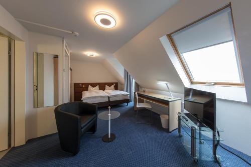 a hotel room with a bed and a desk and a chair at Royal Hotel Zurich in Zürich