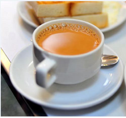 una tazza di caffè su un piatto bianco con pane di Mama Cottage Ella a Ella