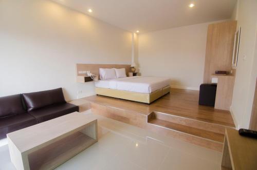 a bedroom with a bed and a couch in a room at U Place Korat in Nakhon Ratchasima
