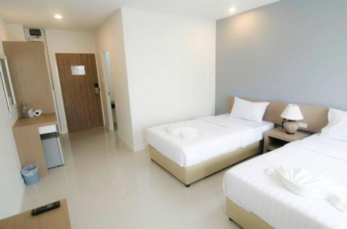 a hotel room with two beds and a bathroom at U Place Korat in Nakhon Ratchasima