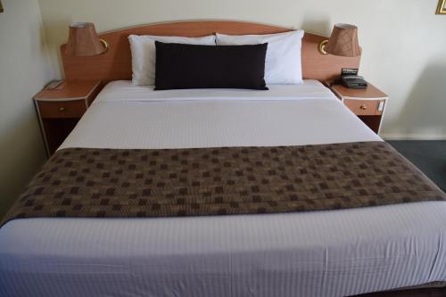 a bedroom with a large bed with two night stands at Best Western Coachman's Inn Motel in Bathurst