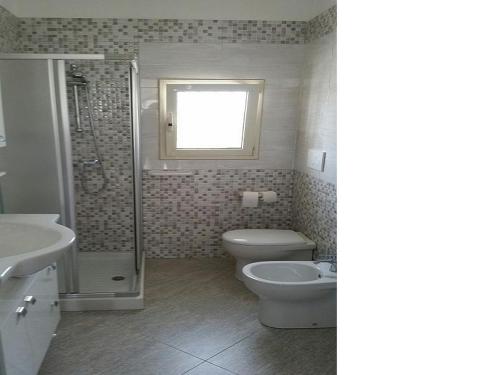 a bathroom with a toilet and a shower and a sink at Casa Vacanza Via Lazio in Torre Lapillo