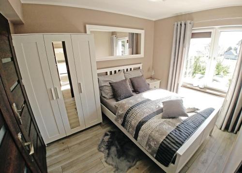 een slaapkamer met een bed en een groot raam bij Apartamenty Aleksandria in Kamień Pomorski