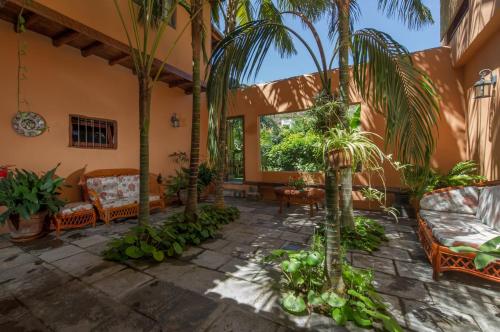 a courtyard with palm trees and couches at Hotel Emblemático San Marcos in Icod de los Vinos