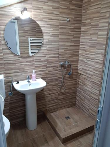a bathroom with a sink and a shower with a mirror at Pensiunea Heaven in Bascov