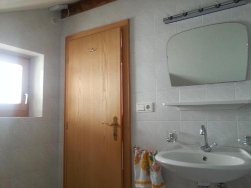 a bathroom with a sink and a mirror and a door at Padoellhof in Curon Venosta