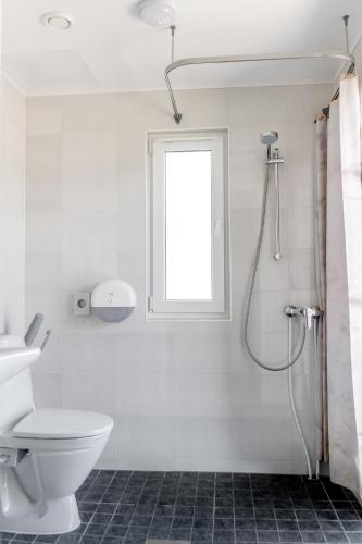 a white bathroom with a toilet and a window at Ermistu Puhkeküla in Ermistu
