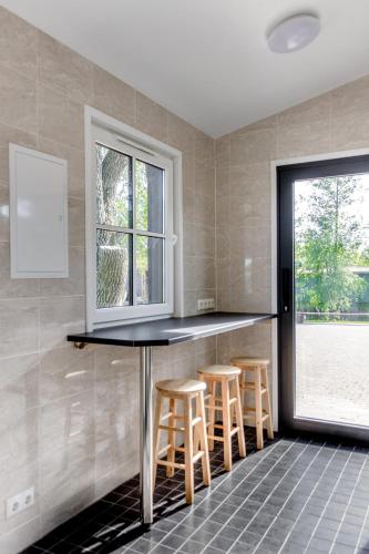 a kitchen with a bar with stools and a window at Ermistu Puhkeküla in Ermistu