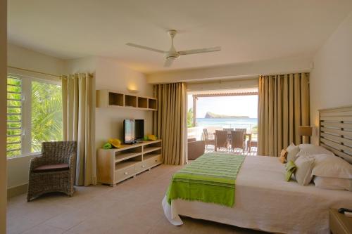 1 dormitorio con cama y vistas al océano en Cape Point Seafront Suites & Penthouse by LOV en Cap Malheureux