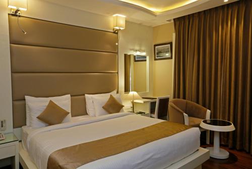 a hotel room with a large bed and a desk at Clarks inn srinagar in Srinagar