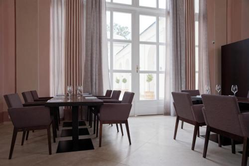 a dining room with a table and chairs and a window at HOTEL Hraniční zámeček in Hlohovec